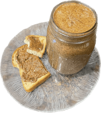 Plate with jar of Pecan Butter and bread with pecan butter on it.